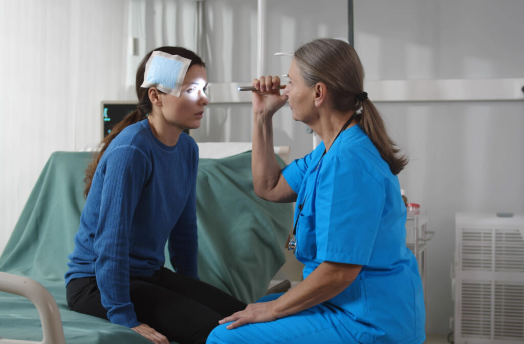 A doctor shining a light to her injured patient's eyes to check for injuries.