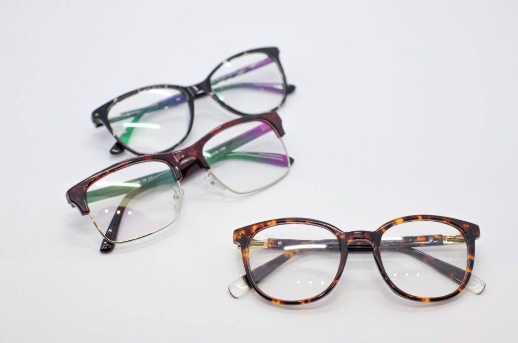 A close-up view of different eyeglass frames on a white table.