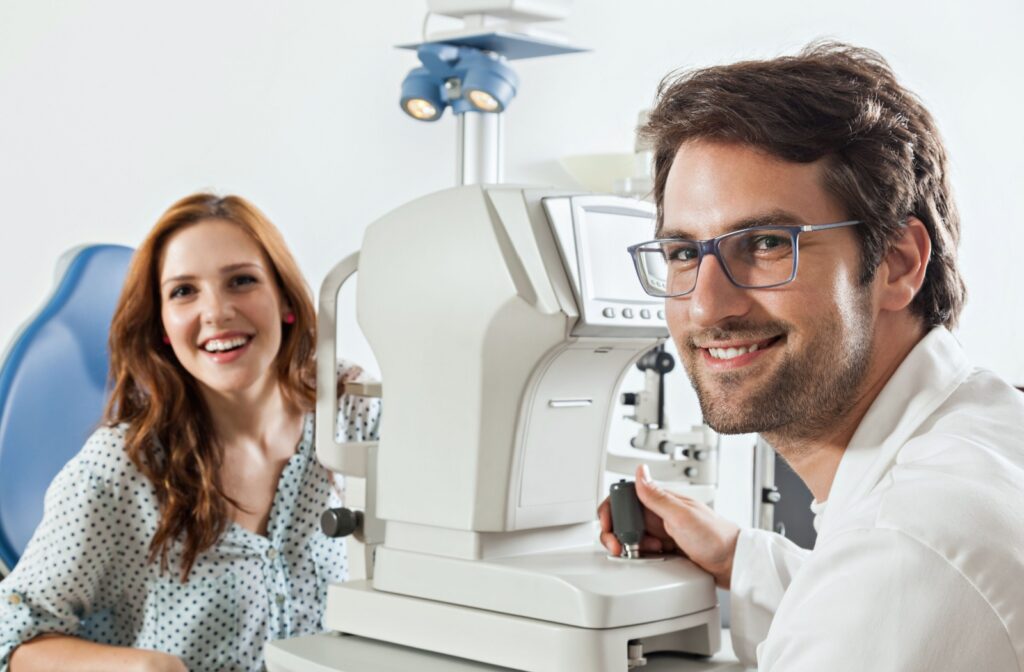 A patient and an optometrist look up after the optometrist finishes examining the patient's retinas during an eye exam.