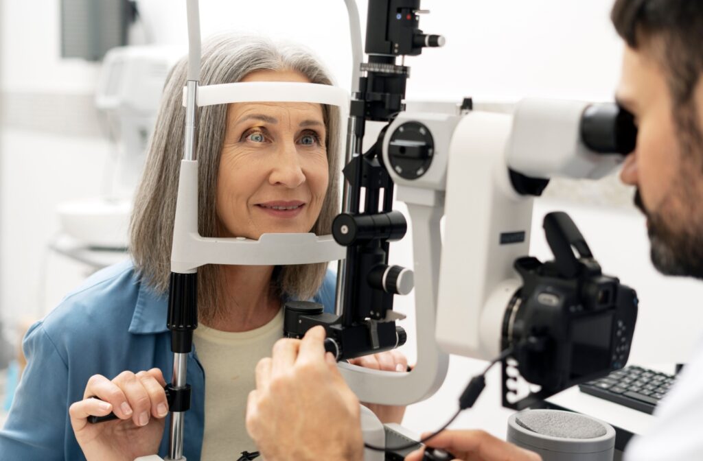 A person sitting up getting a slit lamp test done at the eye doctors
