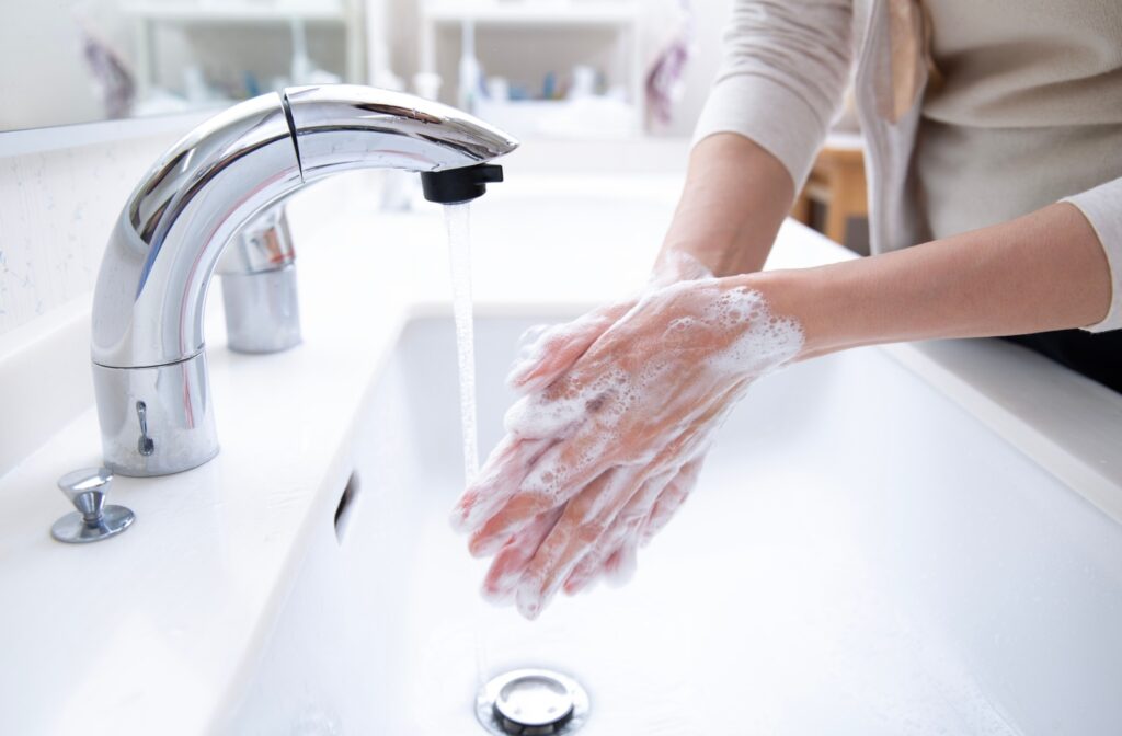 A person using soap to wash their hands at the sink
