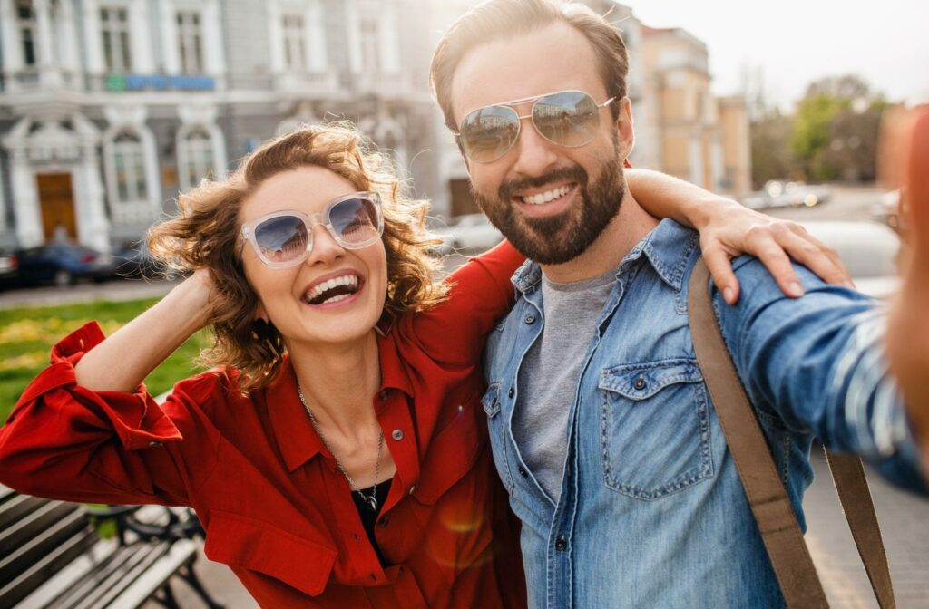 a couple wearing sunglasses while smiling